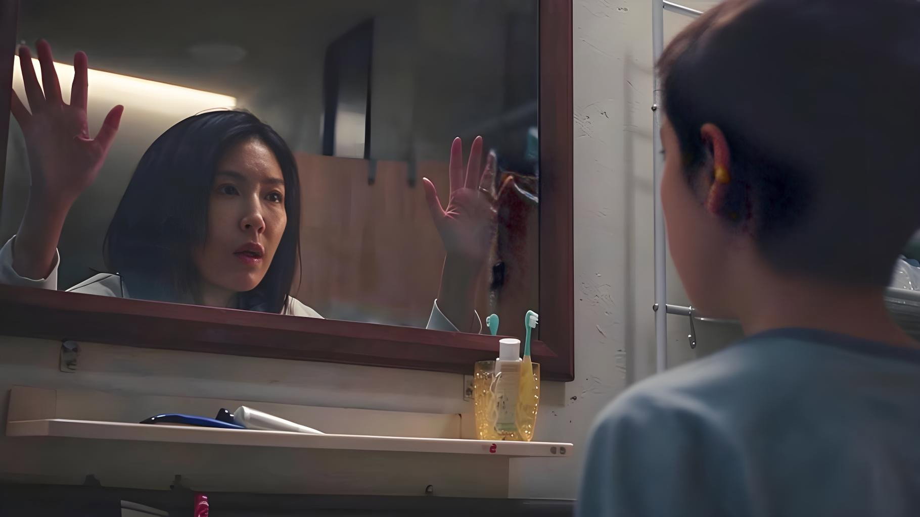 楊謹華飾演的李芸隔著鏡子，與另一端的世界對望。